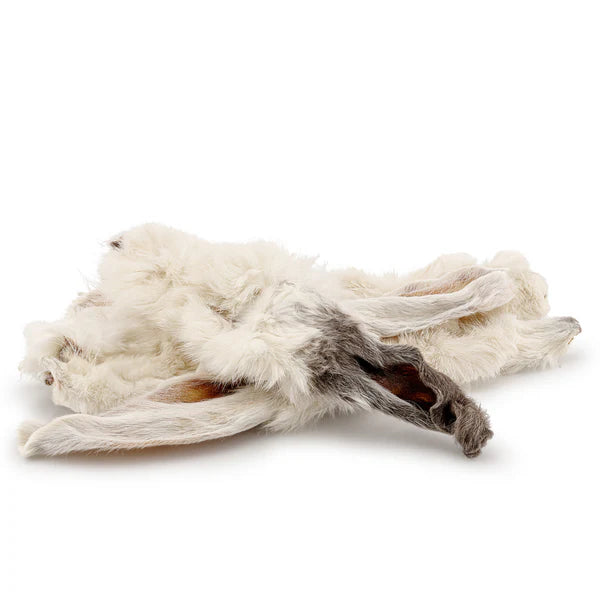A dried, whole rabbit ear with visible fur and skin on a white background.